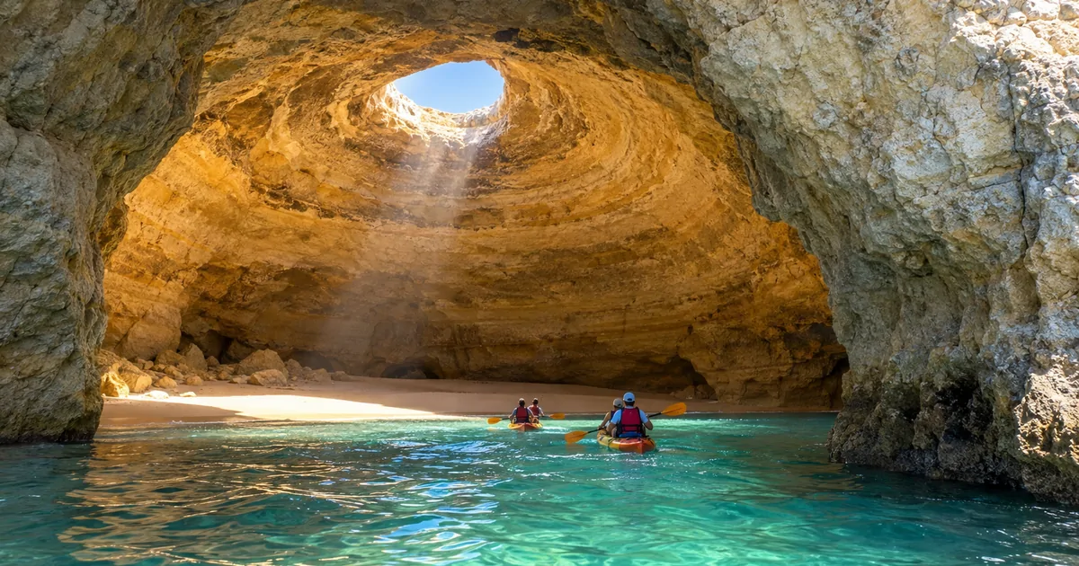 Tandem kayaks with a guide entering Benagil cave through the eastern arch under the skylight beam