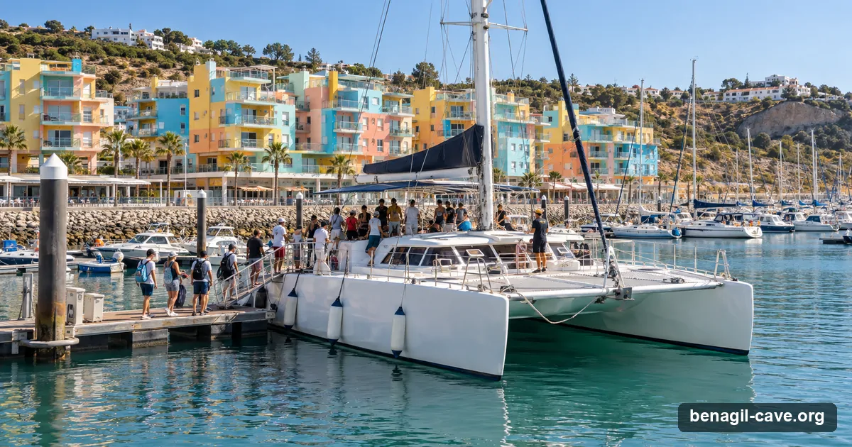 A tour catamaran ready to leave Albufeira marina, with the marina's pastel buildings behind