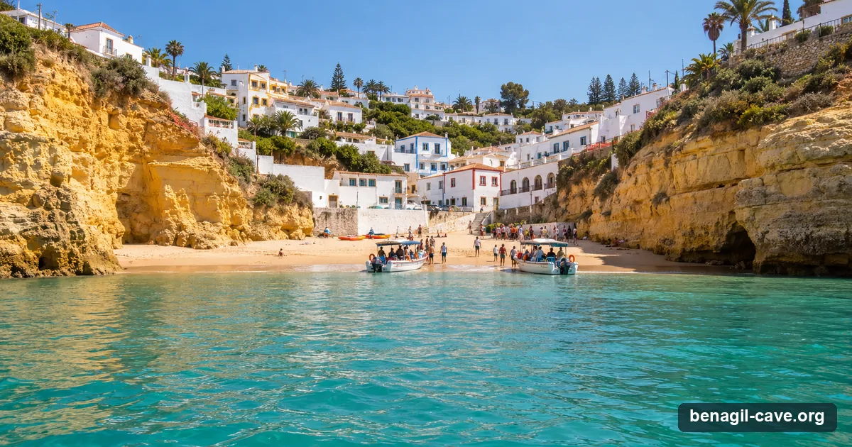 Carvoeiro's beach cove with white houses on the cliffs and small Benagil tour boats loading at the water's edge